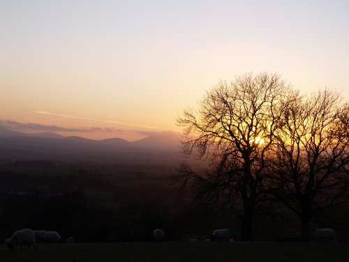Sunset over the Eden valley and the hills and mountains of the Lake District.