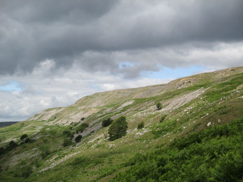 view of the limestone of Fremington Edge Top with the spoil heaps from lead mining and chert quarrying Swaledale North Yorkshire Dales National Park England