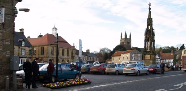 The Market Square in Helmsley, in the foreground is the Lord Faversham memorial and in the distance the tower of Helmsley  Parish Church.