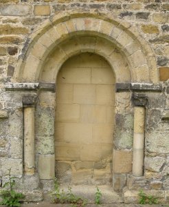The blocked up early Norman doorway in the north wall by the tower and is readily seen as you enter through the gate from the road.
