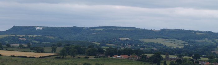 The White Horse of Kilburn on the left, and in the lower right, St Michael's Church Coxwold.