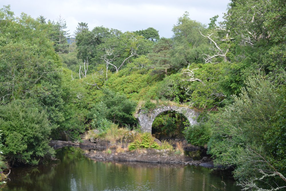 The ruined old stone 17th century road bridge in Glengarriff, known as Old Cromwell's Bridge over the Glengarriff River  West Cork, Ireland
