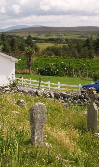125. An old very weathered Celtic cross and holy well in the graveyard near the 'Deserted Village' on the slopes of Slievemore Mountain, Achill Island, Co. Mayo, Ireland. 