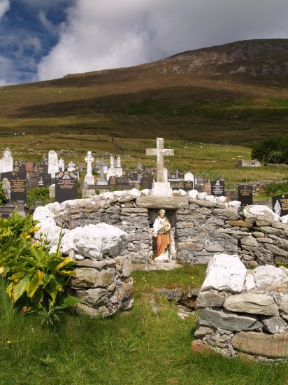 125. An old very weathered Celtic cross and holy well in the graveyard near the 'Deserted Village' on the slopes of Slievemore Mountain, Achill Island, Co. Mayo, Ireland.