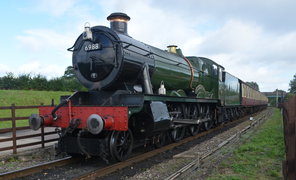 Class 6959 Modified Hall steam locomotive 6990 WITHERSLACK HALL (running as 6988 SWITHLAND HALL) stopping at Quorn and Woodhouse station with a passenger service from Loughborough Central to Leicester North station, Great Central Railway heritage weekend Gala 'Railways at Work' (GCR August 2023)
