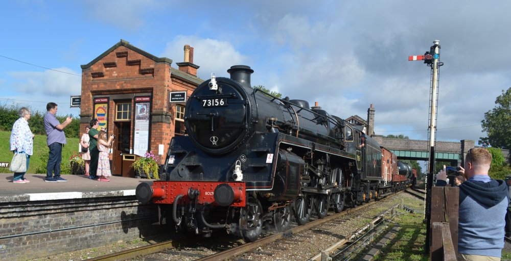 Ex BR standard class 4-6-0 steam locomotive 73156 passing south through Quorn and Woodhouse station with a demonstration freight train, Great Central Railway heritage weekend Gala 'Railways at Work' (GCR August 2023)