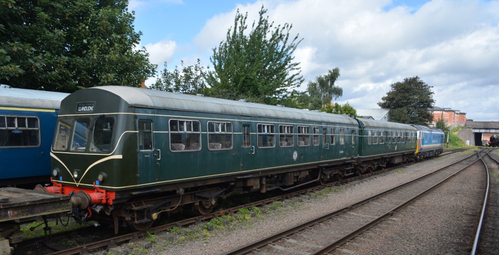 BR Green liveried Class 101 Metro-Cammell DMU unit E 51427 (E51427, DMBS, also carried works unit number 977899) built 1959 and Class 101 Metro-Cammell DMU unit M 50321 (M50321, 53321, DMCL, also carried works number 977900) built 1958, standing south of Loughborough Central station (GCR, August 2023).