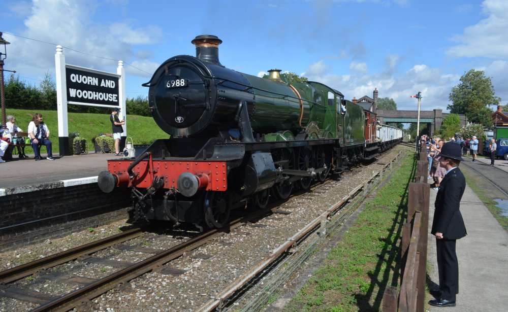 Class 6959 Modified Hall steam locomotive 6990 WITHERSLACK HALL (running as 6988 SWITHLAND HALL) passing south through Quorn and Woodhouse station with a demonstration goods train, Great Central Railway heritage weekend Gala 'Railways at Work' (GCR August 2023).