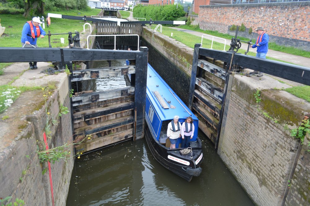 narrow boat passing through the Diglis Lock assisted by members of the Canal and River Trust River Severn Worcester England