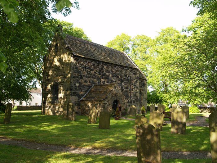 The church at Escomb stands in its enclosed 'green' space' in the middle of a housing estate. The porch was added in the 12th century.