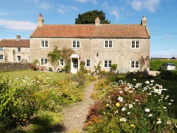 Cold Kirby is essentially a one, wide street village with a number of attractive stone houses, most of which have a lovely flower garden - Walking from Sutton Bank National Park Visitor Centre, North York Moors National Park, North Yorkshire, Northern England