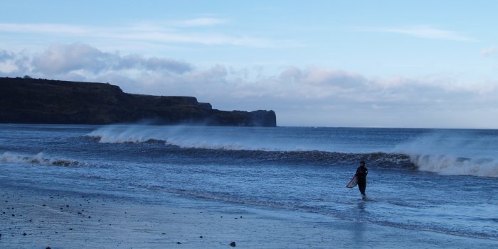 Looking north-west towards Lythe from Sandsend beach as a surfer exits the cold water!