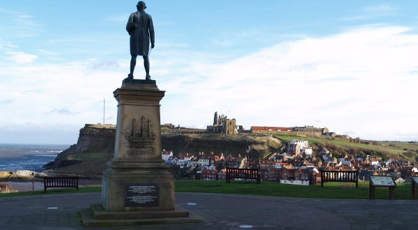 The memorial to Captain James Cook on West Cliff, looking across to Whitby Abbey and St Mary's Church.  A profile of his ship, the 'Resolution', is carved in the base