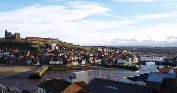 Looking across the harbour bridge and boats and on the left Whitby Abbey and St. Mary's Church