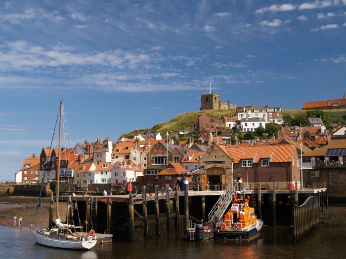 The RNLI lifeboat tied up in Whitby Harbour below the East Cliff with St Mary's Church above.