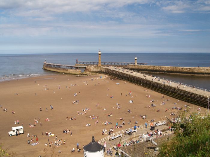 The west beach by the harbour entrance walls of the West Pier on a fine summer's day