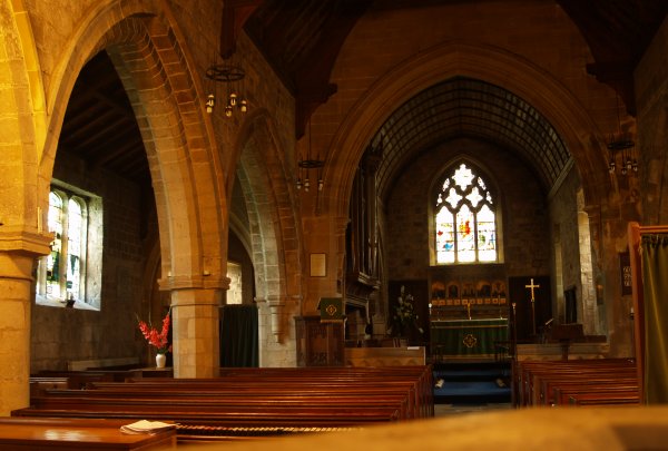 Looking east down the nave to the chancel and altar of St Helen, on the left two 14th century arches.