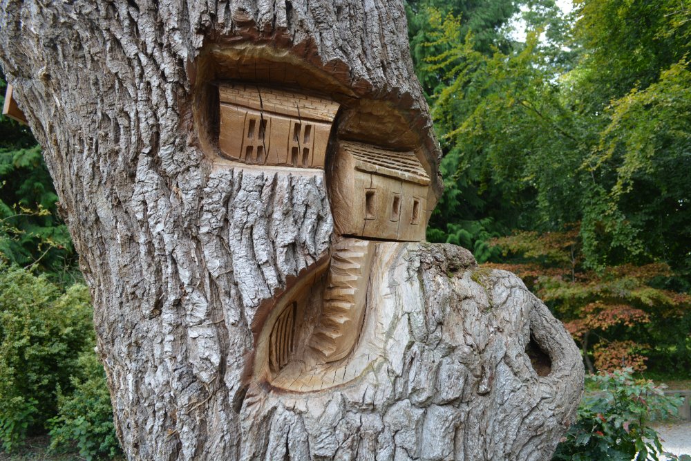 Wooden house sculpture carved on a tree trunk Thorp Perrow Arboretum & Bird of Prey & Mammal Centre, North Yorkshire, England