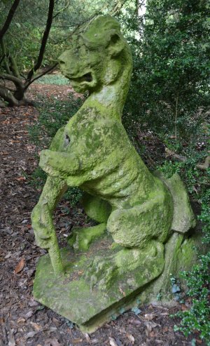 Stone sculptured figure of strange beast in Thorp Perrow Arboretum & Bird of Prey & Mammal Centre, North Yorkshire, England
