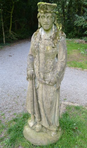 Stone sculptured figure of medieval man in Thorp Perrow Arboretum & Bird of Prey & Mammal Centre, North Yorkshire, England