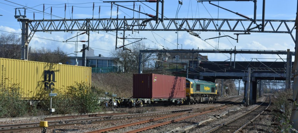 A Class 66 Freightliner diesel locomotive passing south through Nuneaton station with an intermodal freight train from Birmingham Lawley Street F.L.T to London Gateway Freightliner (Trainspotting March 2023).
