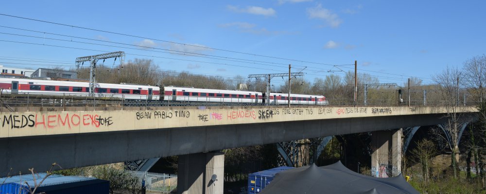 Viewed from the Byker Bridge, an LNER express train passing over the Ouseburn Viaduct with the Metro train Byker viaduct in the foreground