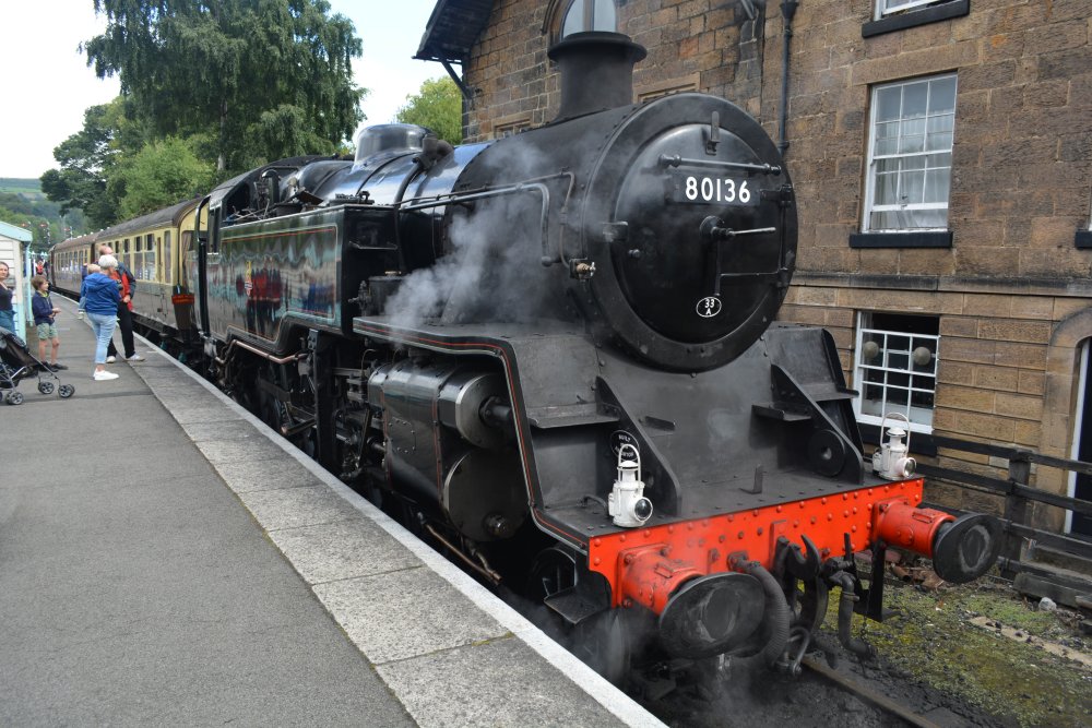 At the head of the 'Moorlander' Pullman car dining service train to Pickering is BR standard 2-6-4T tank engine 80136 in Grosmont station on the NYMR heritage railway (Oct 2023)
